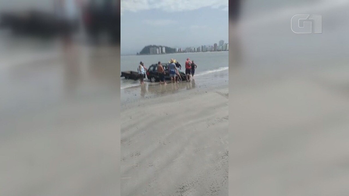 Carro atola em praia de SP e mobiliza banhistas em operação de resgate