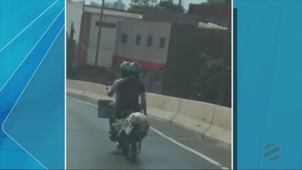 Passageiro De Moto Flagrado Carregando Carrinho De M O Em Viaduto De