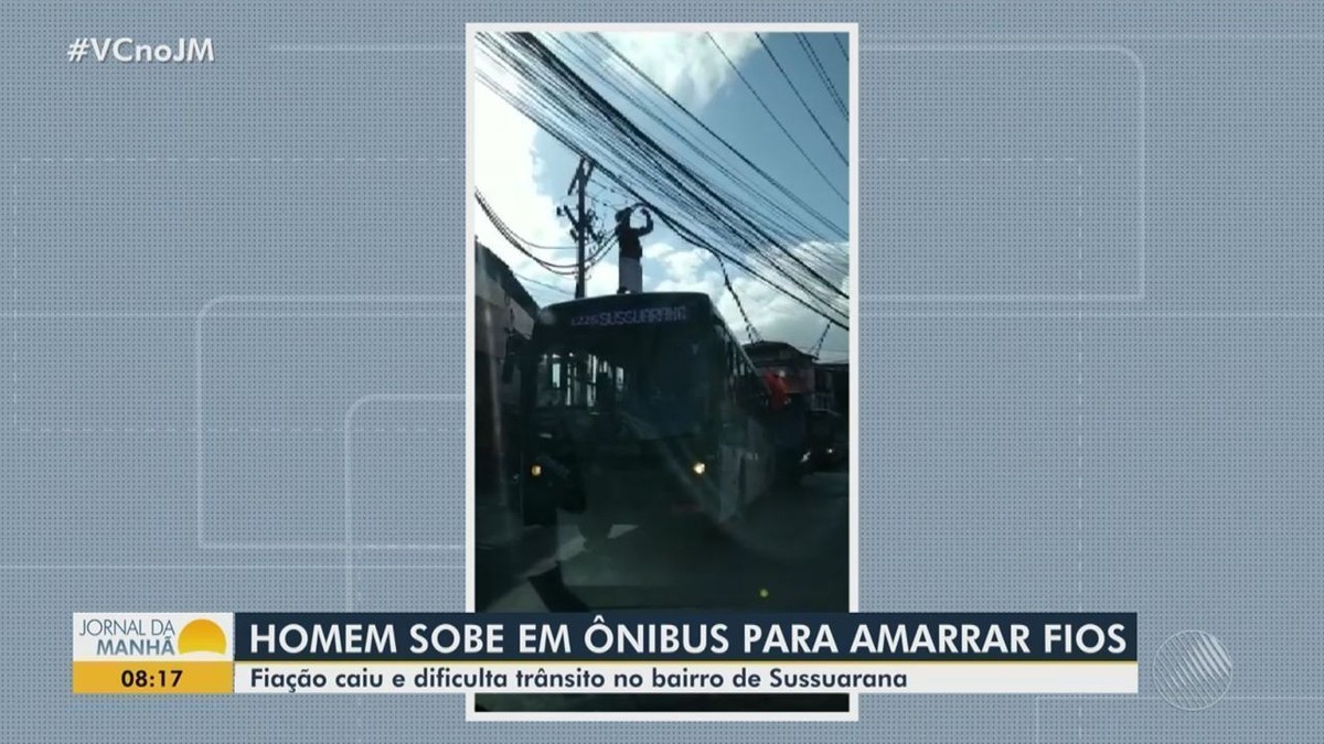 Homem sobe em ônibus para amarrar fiação que caiu de postes no bairro