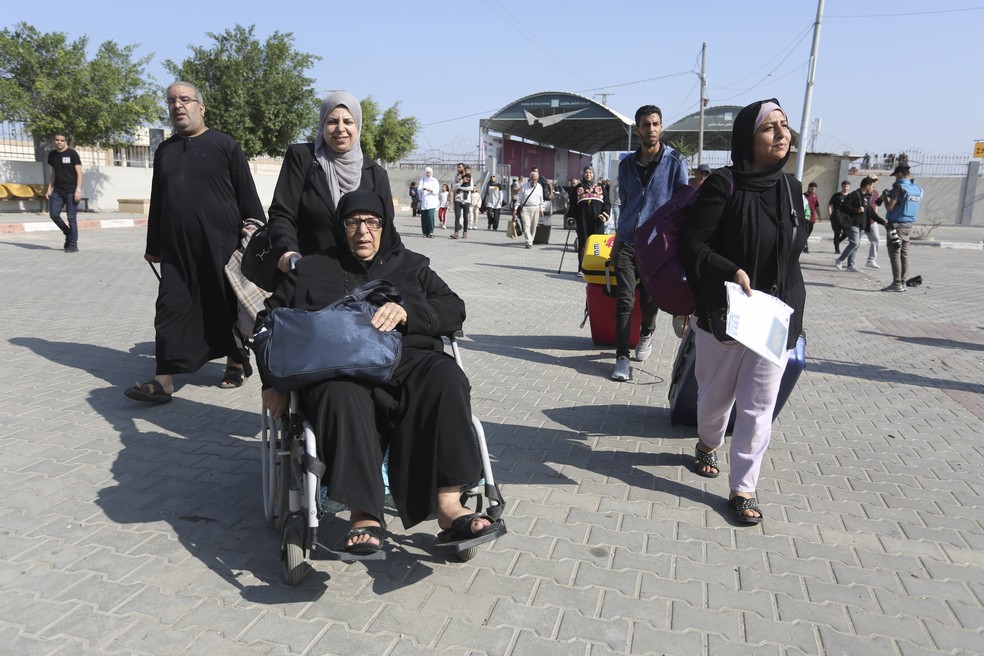 Estrangeiros cruzam a fronteira da Faixa de Gaza em Rafah — Foto: Hatem Ali / AP Photo