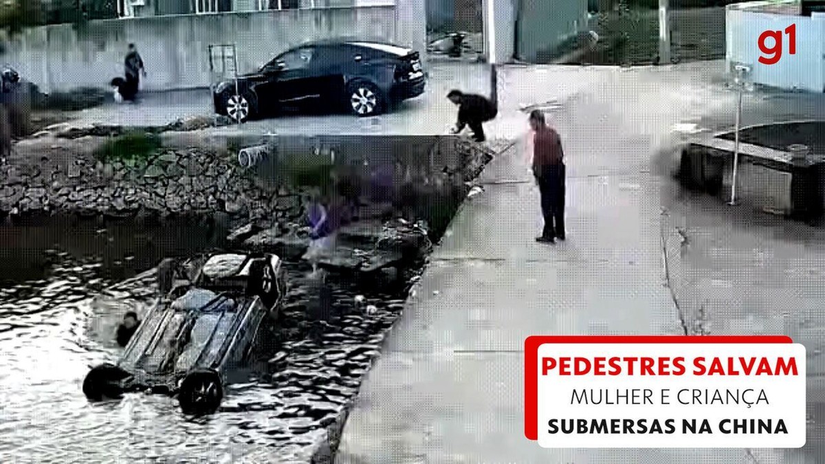 Carro cai em rio, e pedestres salvam mulher e criança que ficaram submersas; VÍDEO