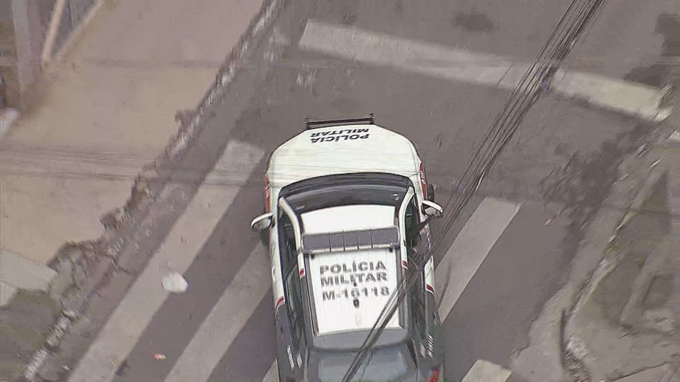 Viatura com agente andando com arma para fora em Paraisópolis. — Foto: Reprodução/ TV Globo