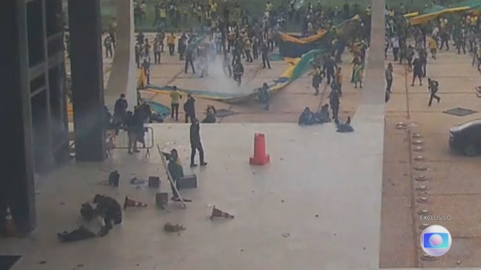 Do lado de fora do STF, um policial que tentava conter a invasão dá um soco em um vândalo — Foto: Jornal Nacional/ Reprodução