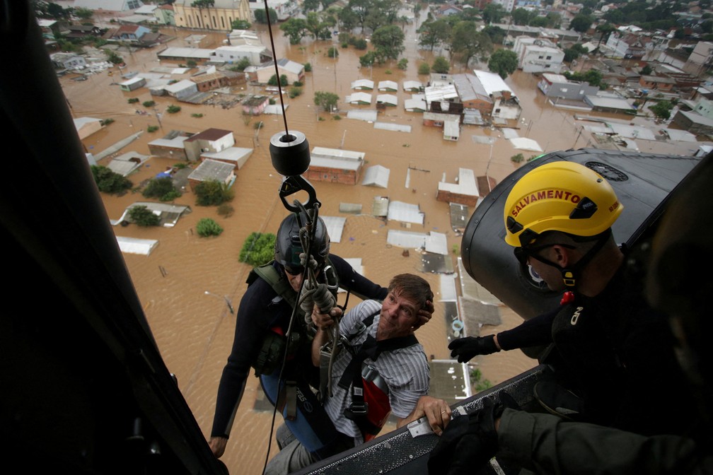 4 de maio - Homem é resgatado por bombeiros em Canoas em meio às enchentes que atingiram o Rio Grande do Sul — Foto: Renan Mattos/Reuters