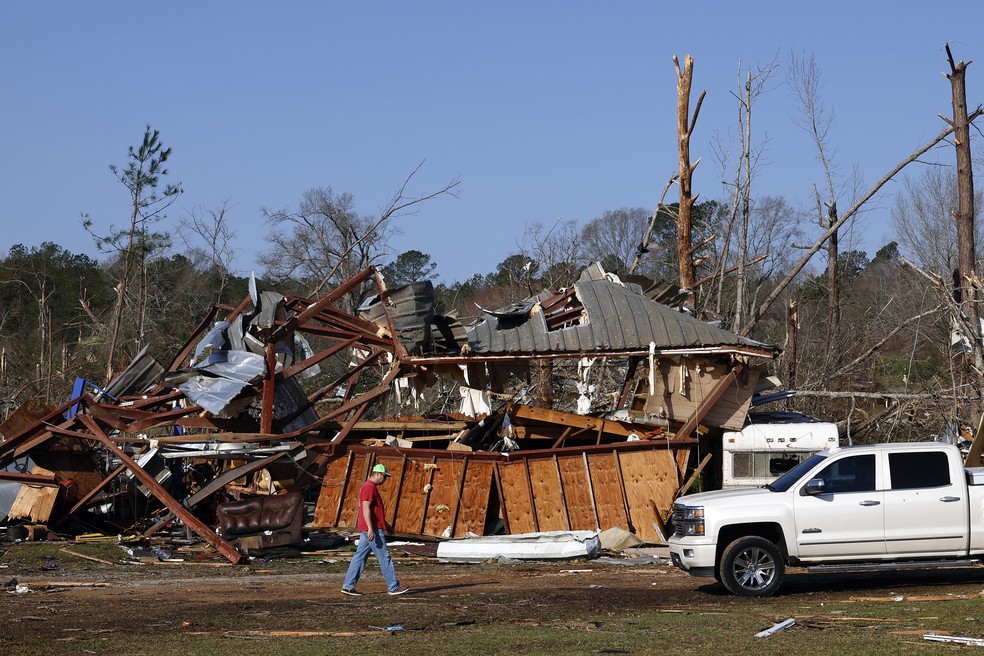 Moradores procuram pertences entre os destroços após a passagem de um tornado que deixou duas pessoas mortas, no domingo (16), em Plantersville, Alabama. — Foto: AP/Butch Dill