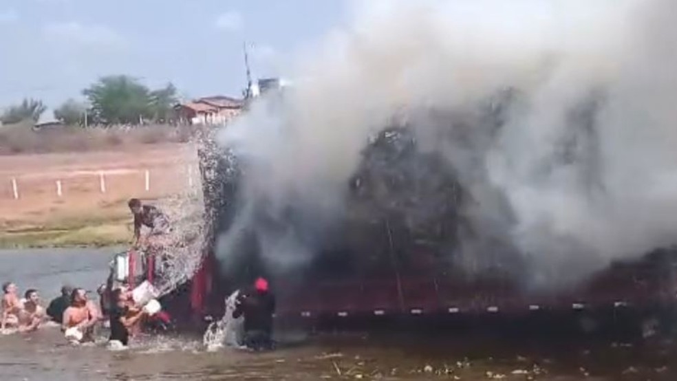 Populares usaram baldes com água para apagar as chamas no caminhão. — Foto: Reprodução