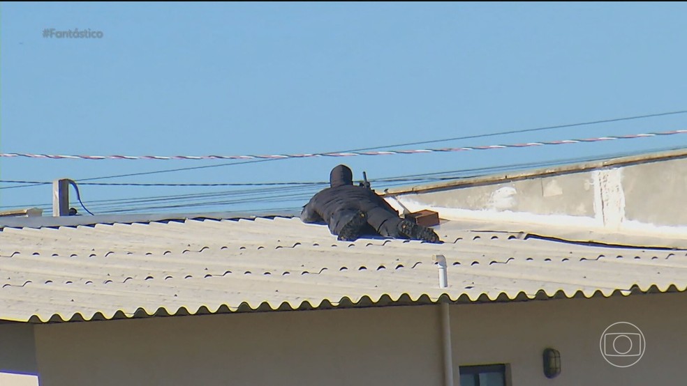 Atirador posicionado em cima de uma casa durante caçada ao criminoso no RN — Foto: Reprodução/TV Globo