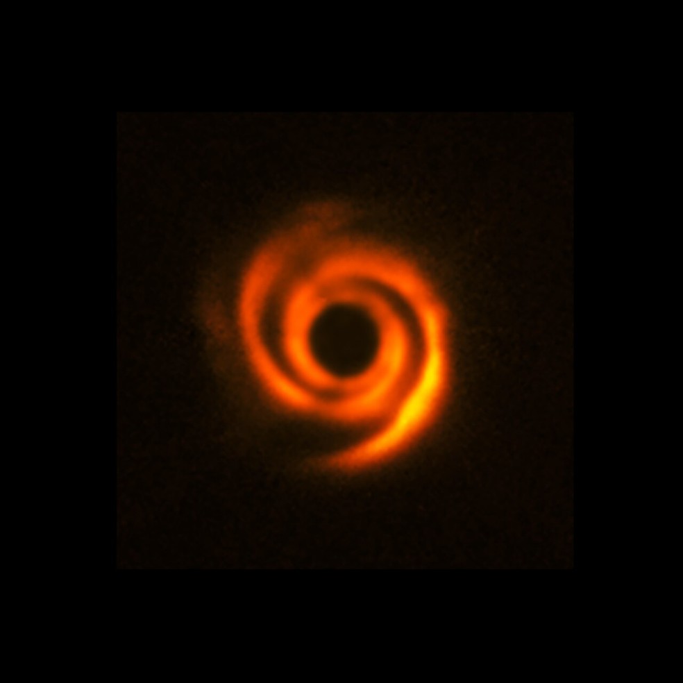 Imagem de 2016 mostra disco espiral de poeira ao redor da estrela HD 135344B, feita com o telescpio VLT. A estrela foi ocultada pelo crculo preto para destacar os detalhes. Sinais de um possvel planeta s foram detectados em observaes mais recentes.  Foto: ESO/T. Stolker et al.