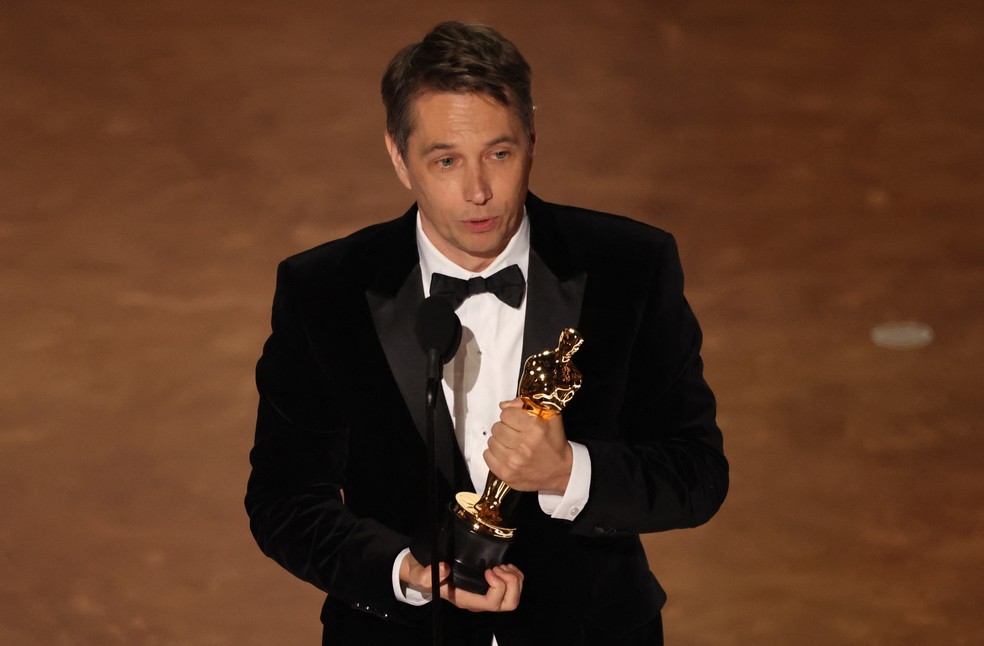 Sean Baker recebe Oscar de melhor roteiro original por 'Anora' — Foto: Carlos Barria/Reuters