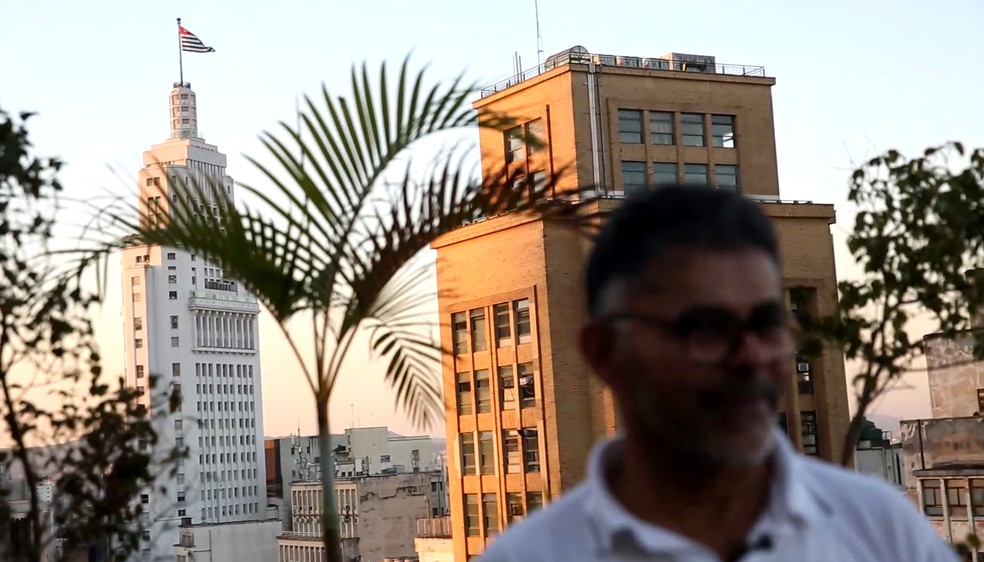 Everaldo Batista dos Santos, na cobertura do Edifício Triângulo, com o Farol Santander ao fundo — Foto: Fábio Tito/g1