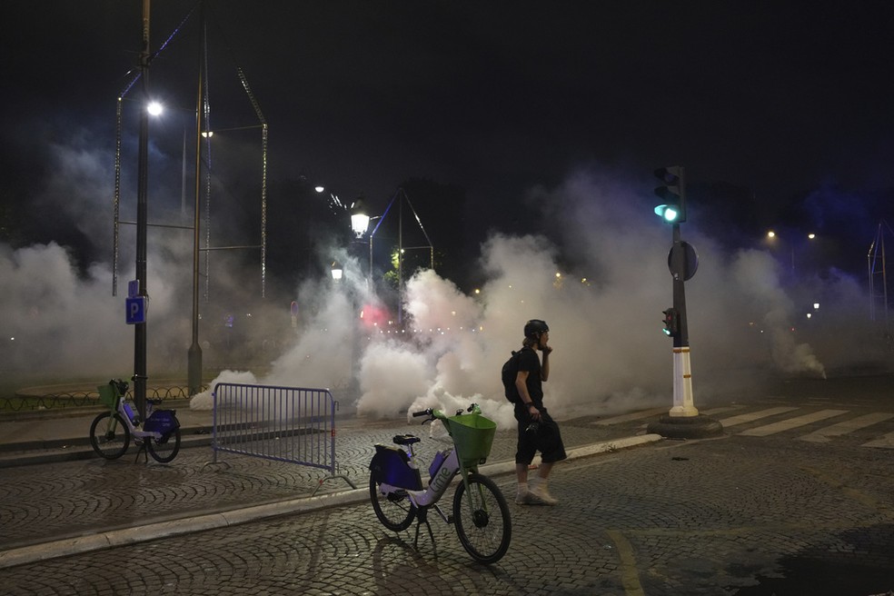 Polícia usou gás lacrimogêneo para dispersar a confusão provocada por torcedores do PSG em Paris — Foto: Aurelien Morissard/AP