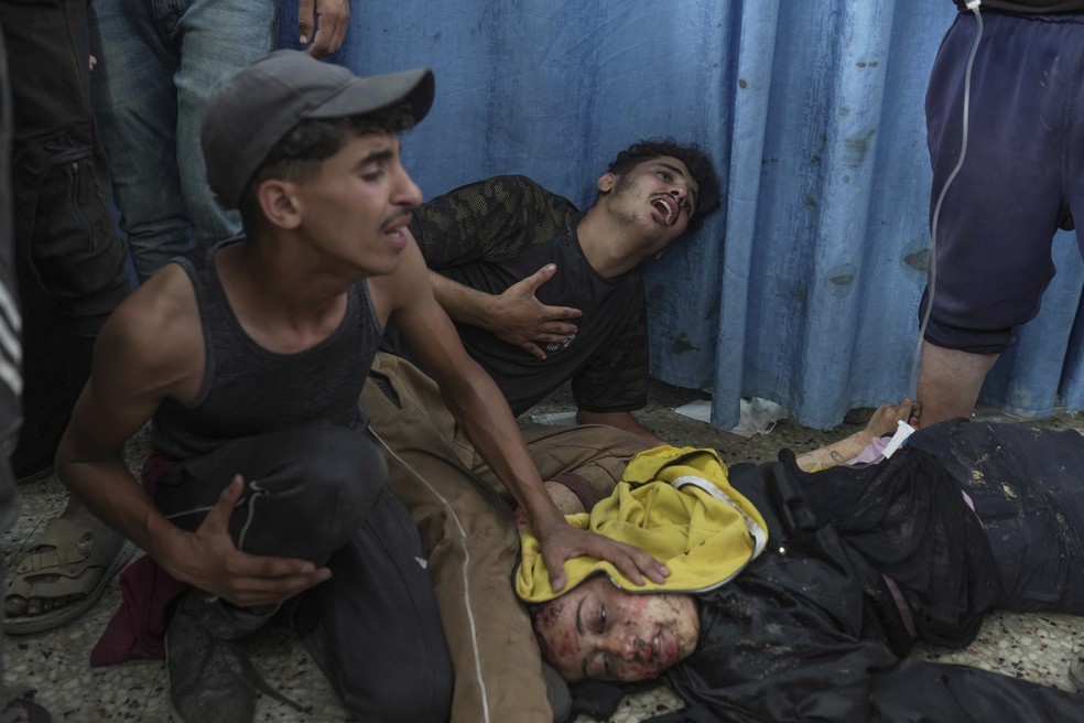 Palestinos reagem ao lado de sua irmã ferida em um ataque aéreo israelense, enquanto ela é levada ao Hospital Shifa na Cidade de Gaza — Foto: Foto AP/Jehad Alshrafi