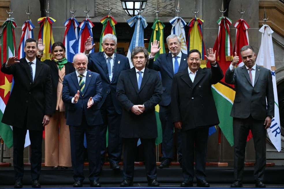 Cúpula do Mercosul na Argentina: (Da esquerda para a direita, atrás) a vice-presidente do Equador, Maria José Pinto, o presidente do Panamá, José Raúl Mulino, e o ministro das Relações Exteriores do Chile, Alberto van Klaveren; (da esquerda para a direita, na frente) o presidente do Paraguai, Santiago Pena, o presidente do Brasil, Luiz Inácio Lula da Silva, o presidente da Argentina, Javier Milei, o presidente da Bolívia, Luis Arce Catacora, e o presidente do Uruguai, Yamandu Orsi — Foto: Luis Robayo/ AFP