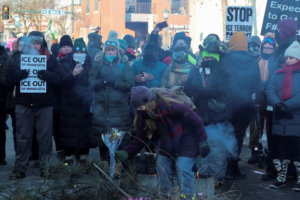 Mulher coloca flores em local onde homem foi morto por agente de imigração em Minneapolis, nos EUA; protestos foram retomados depois da operação — Foto: Evelyn Hockstein/Reuters