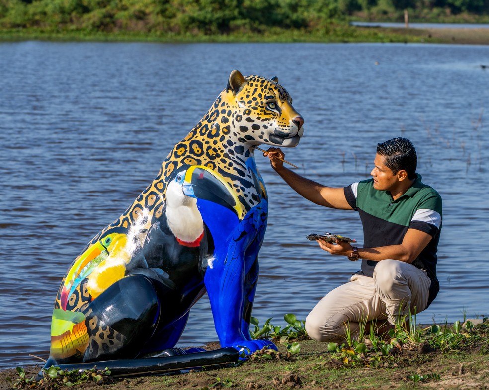 O artista Petterson Silva e a obra 'Joia da Mata' no Pantanal de MT — Foto: Sebastian Kennerknecht