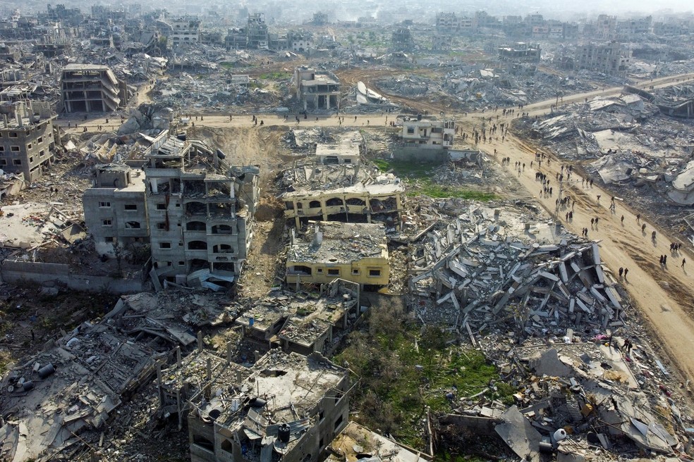 Visão de drone mostra palestinos deslocados caminhando pelos escombros enquanto tentam retornar para suas casas, em meio a um cessar-fogo entre Israel e o Hamas, no norte da Faixa de Gaza. — Foto: REUTERS/Mahmoud Al-Basos