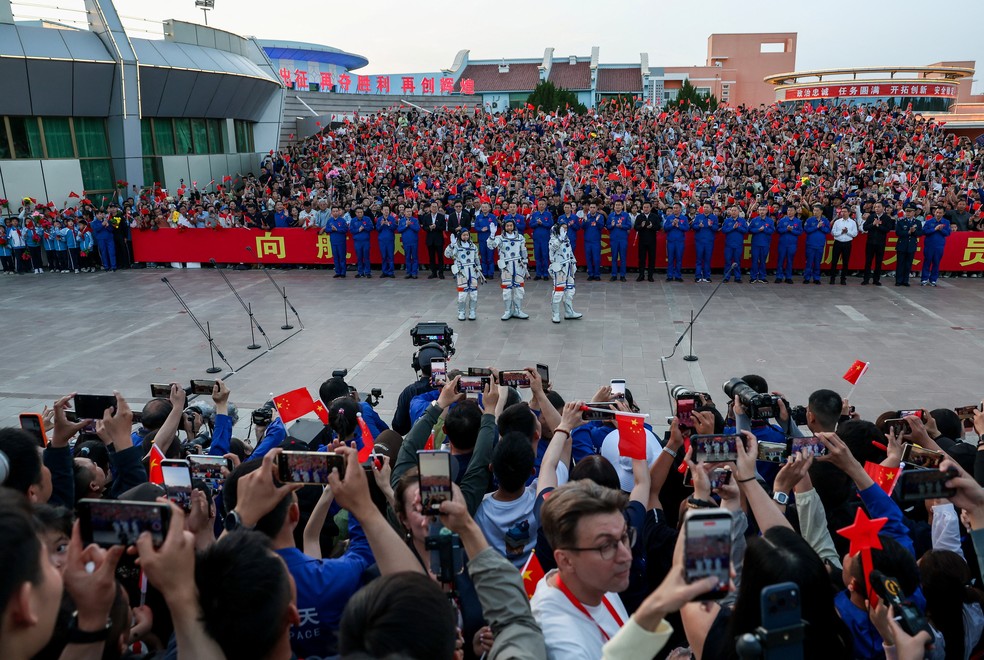 Os astronautas Zhu Yangzhu, Zhang Zhiyuan e Lai Ka-ying, o primeiro astronauta de Hong Kong, acenam durante uma cerimônia de despedida antes de participarem da missão espacial Shenzhou-23 rumo à estação espacial  chinesa Tiangong — Foto: REUTERS/Maxim Shemetov