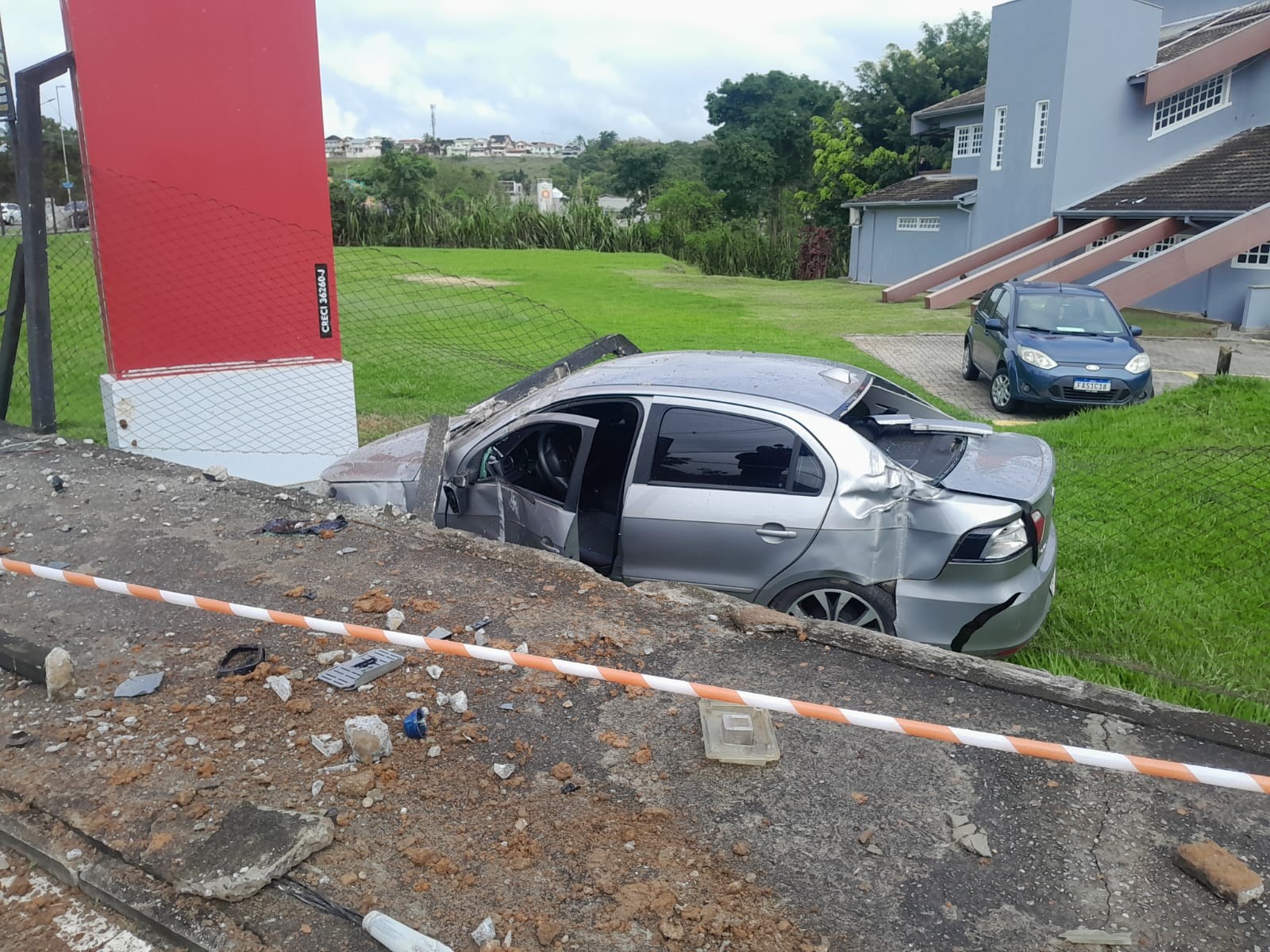 Carro bate em poste, derruba fiação e cai em estacionamento de imobiliária em São José dos Campos