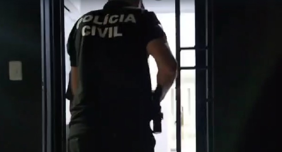 Policial conduz suspeito para dentro de delegacia no Oeste potiguar — Foto: Reprodução