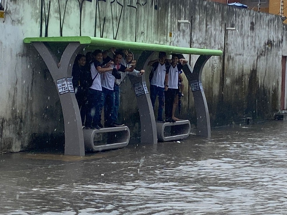 Estudantes se abrigam da chuva na avenida Jerônimo Câmara, na Zona Sul de Natal - Terça (18) — Foto: Pedro Trindade / Inter TV Cabugi