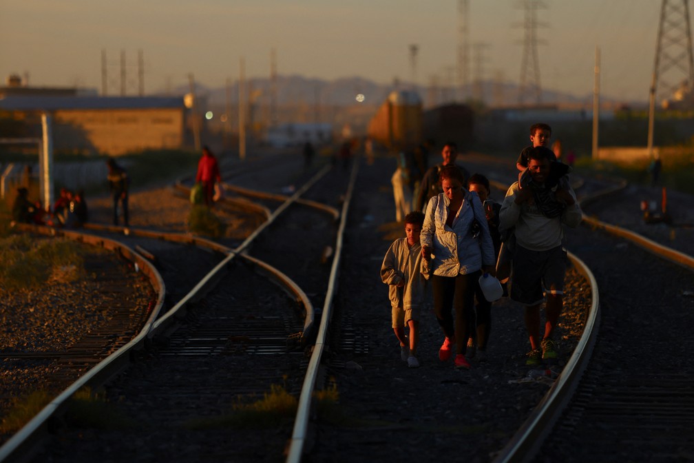 Família caminha em trilho de trem na chegada a Ciudad Juárez, no norte do México, onde milhares tentam entrar nos EUA diariamente, em 3 de outubro de 2023. — Foto: Jose Luis Gonzalez/ Reuters