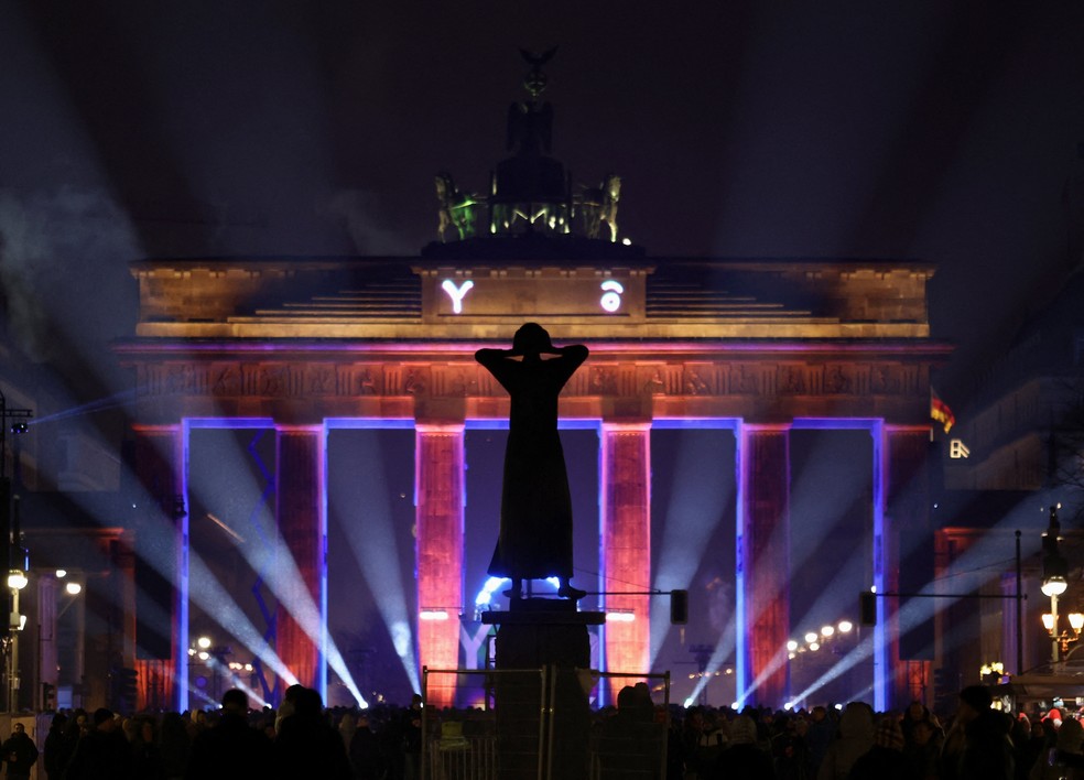 Pessoas às vésperas do Ano Novo na frente do Portão de Brandemburgo, em Berlim, na Alemanha. — Foto: Maryam Majd/Reuters