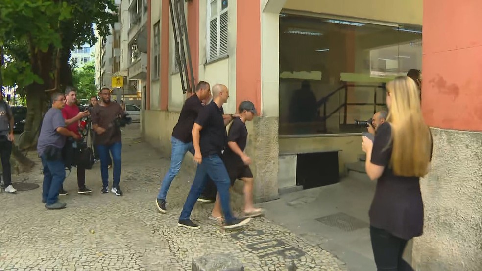 Mattheus Verissimo Zoel Martins na chegada à delegacia de Copacabana — Foto: Lucas Peçanha/ TV Globo