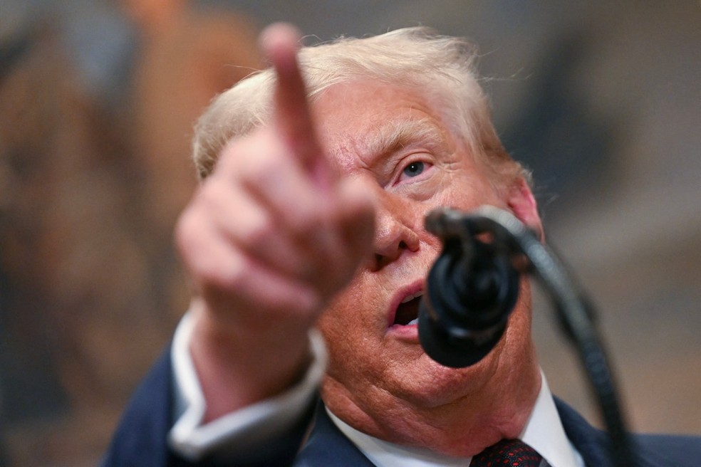 Presidente dos EUA, Donald Trump, aponta durante discurso em 31 de julho de 2025 — Foto: Jim Watson/AFP)