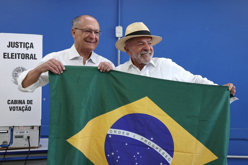 O presidente brasileiro e candidato � reelei��o pelo Partido dos Trabalhadores (PT), Luiz In�cio Lula da Silva, segura a bandeira nacional ao lado do vice-presidente Geraldo Alckmin, ao chegar para votar nas elei��es gerais em S�o Bernardo do Campo, Brasil, em 4 de outubro de 2026 � Foto: REUTERS/Amanda Perobelli