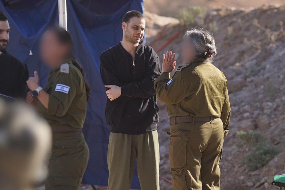 Refém libertado Alon Ohel com representantes das Forças de Defesa de Israel (IDF) — Foto: Divulgação/IDF