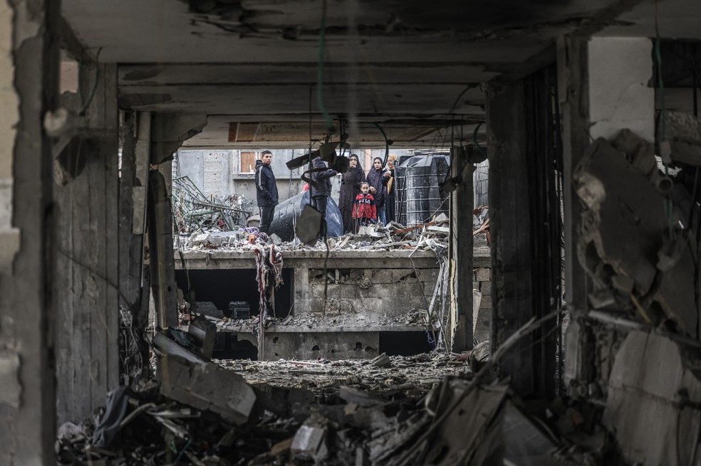 Guerra em Gaza: palestinos observam destruição causada por bombardeio de Israel em Rafah, em 9 de fevereiro de 2023. — Foto: Mahmud Hams / AFP