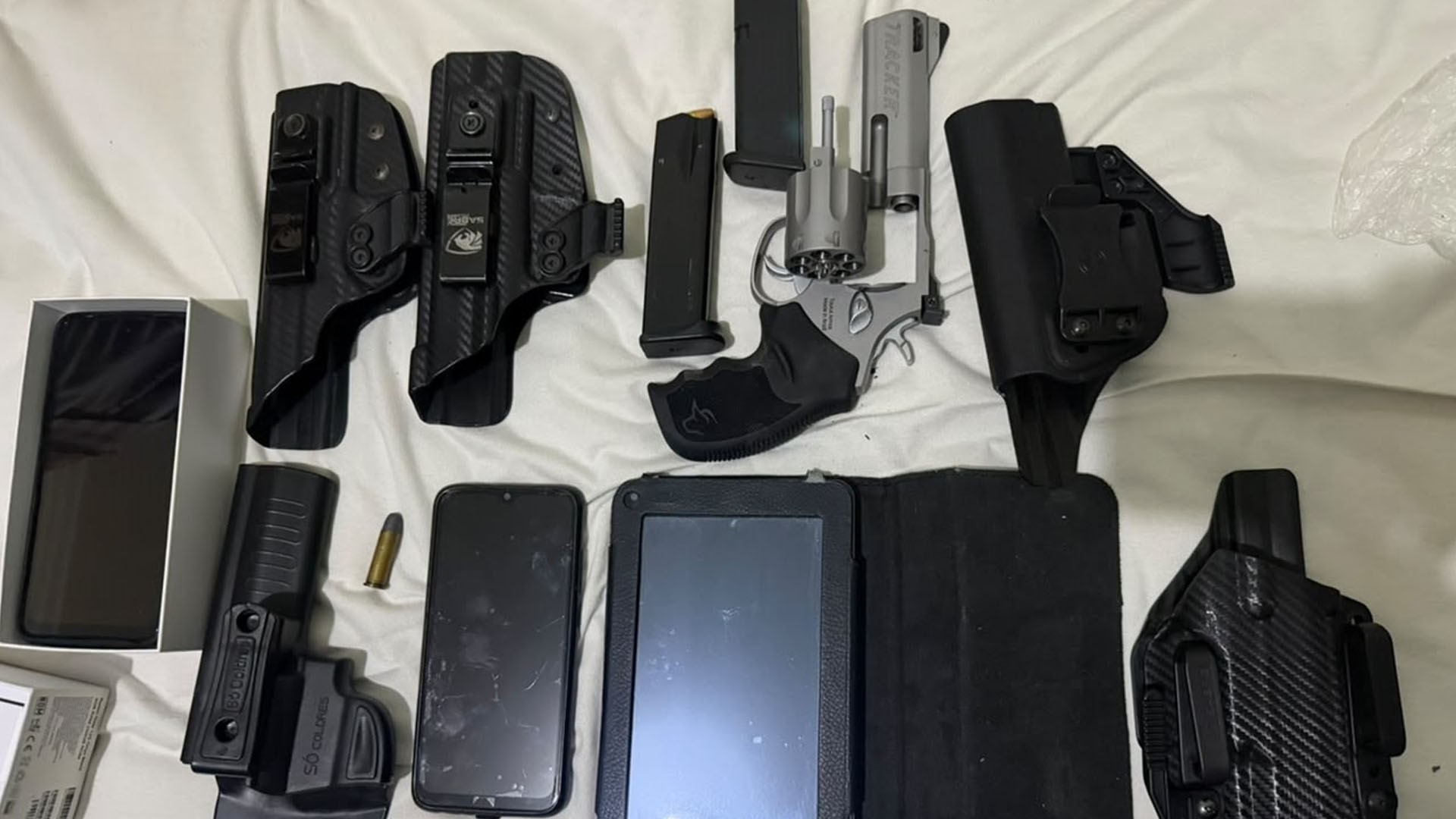 Polícia apreende arma, munição e celulares em ação contra policial penal réu por matar homem em frente a bar
