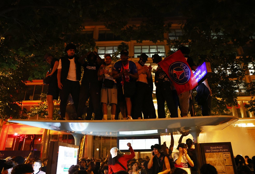 Torcedores do PSG sobem em cima de ponto de nibus durante celebrao do ttulo da Champions League, em Paris  Foto: Abdul Saboor/Reuters