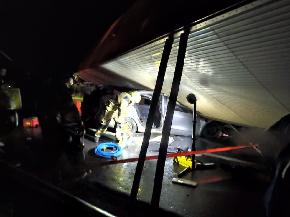 Carreta tombou em cima do carro — Foto: Corpo de Bombeiros