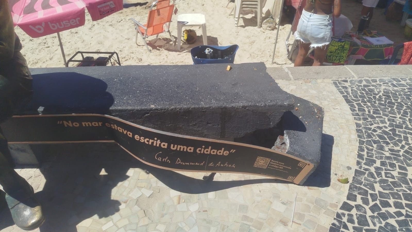 Turista quebra banco da estátua de Drummond ao tentar abrir coco em Copacabana