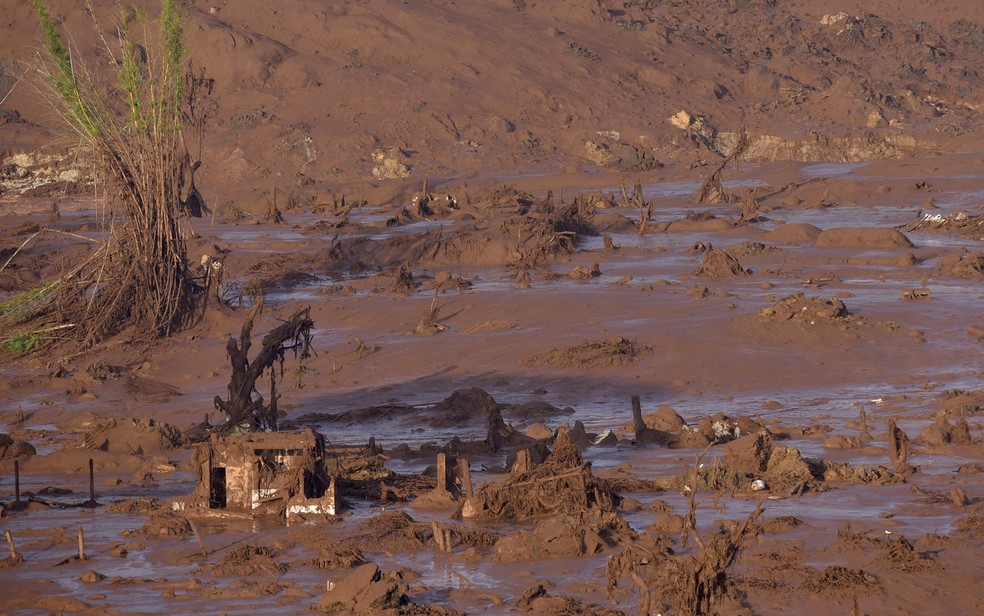 06/11 - Destroços de construções são vistos em meio a lama após o rompimento de uma barragem de rejeitos da mineradora Samarco no Distrito de Bento Rodrigues, no interior de Minas Gerais — Foto: Douglas Magno/AFP