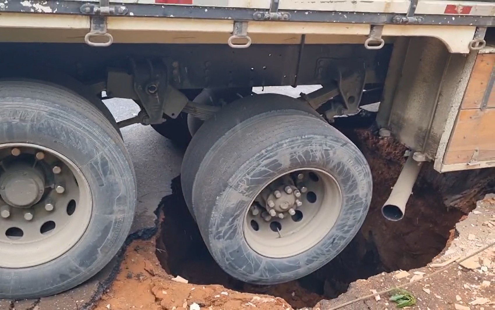 Caminhão com tijolos afunda após buraco abrir enquanto veículo passava por rua de Passos, MG