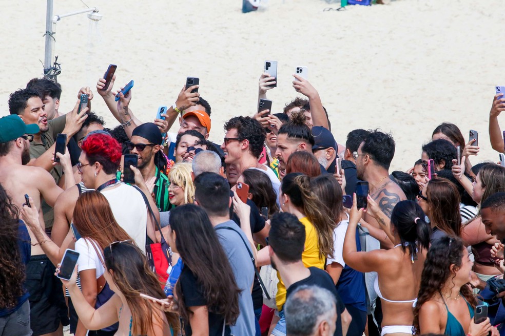 Shawn Mendes é cercado por fãs na praia de Ipanema. — Foto: JC Pereira/Agnews