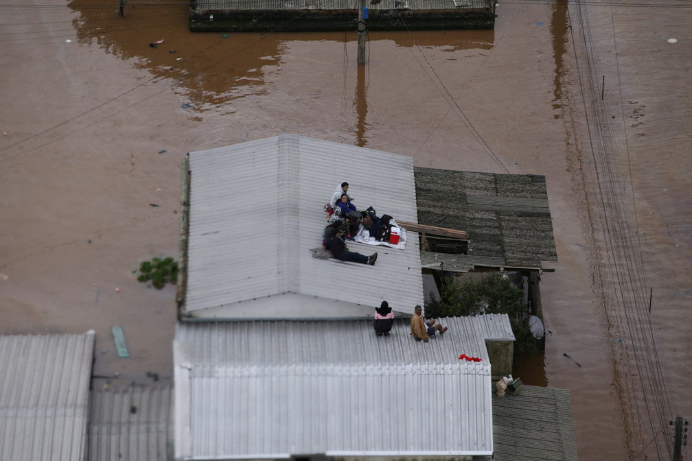 4 de maio - Moradores aguardam resgate no telhado de casa em Canoas, no Rio Grande do Sul — Foto: Renan Mattos/Reuters