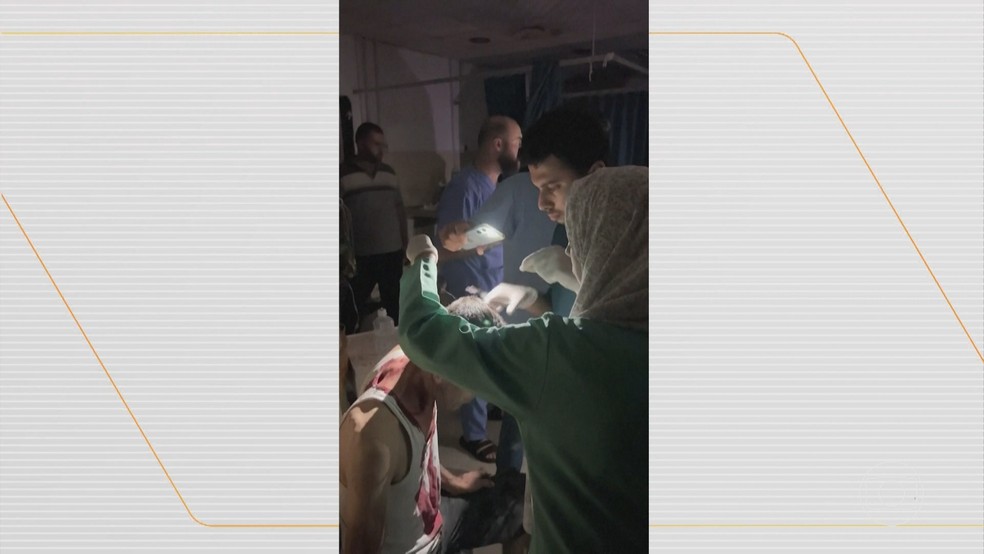 Falta de energia nos hospitais da Faixa de Gaza fez com que médicos precisassem atender pacientes com a luz da lanterna de celular. — Foto: Reprodução/Bom Dia Brasil