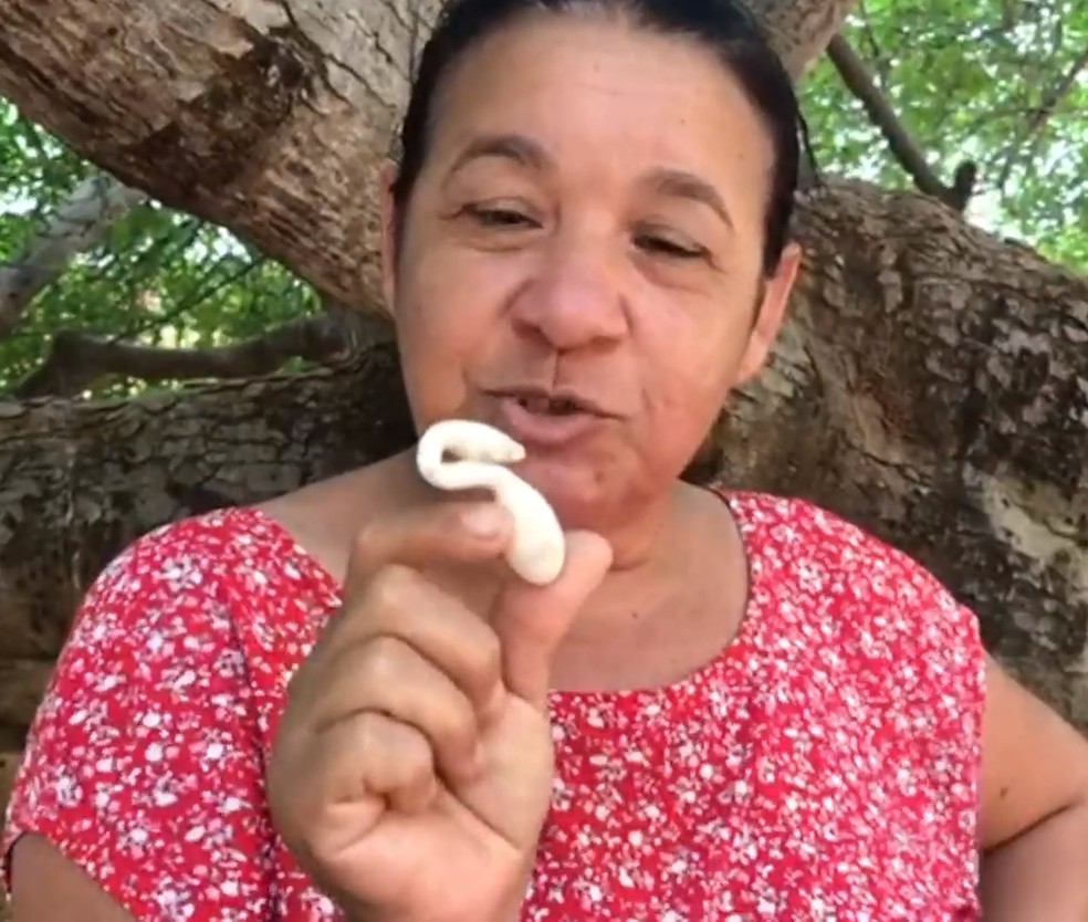 Givaneide Barbosa, filha da agricultora Edite, mostra o ovo que nasceu com um formato diferente no RN — Foto: Reprodução/Inter TV Cabugi
