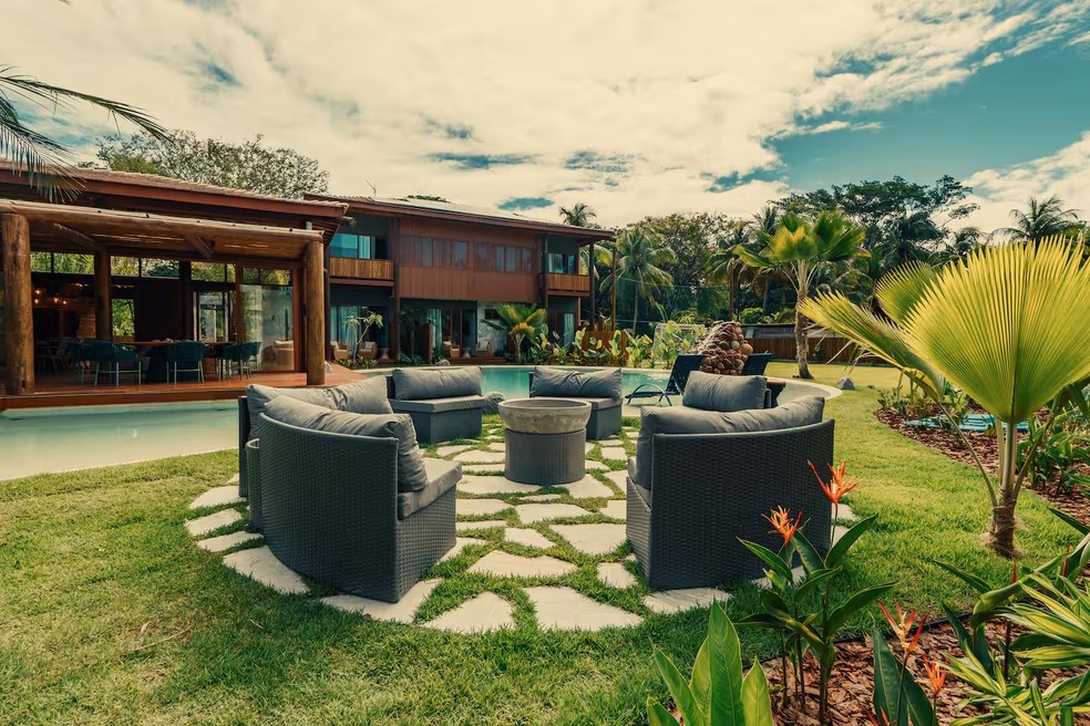 O espaço ainda reúne áreas abertas de convivência e um "fire pit", fogueira de exterior, projetada para conter o fogo de forma segura em jardins, varandas e áreas de convivência — Foto: Reprodução/Redes Sociais
