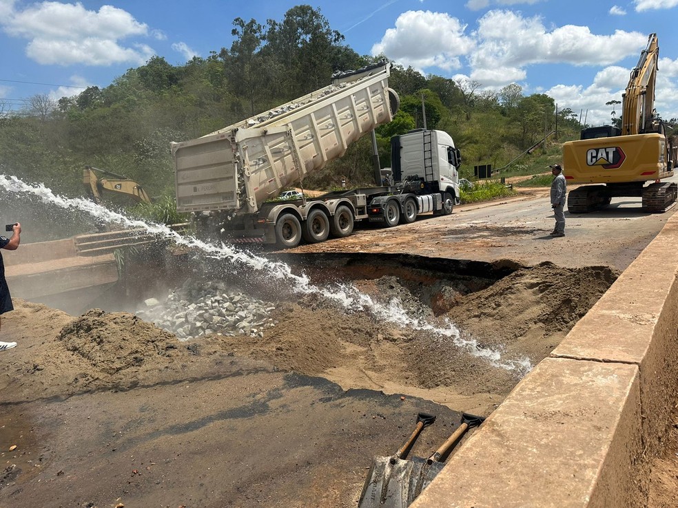 Técnicos do DNIT usam água, areia e paralelepípedo para fechar cratera aberta após rompimento de cabeceira de ponte em Teotônio Vilela, Alagoas — Foto: Nick Marone/TV Gazeta