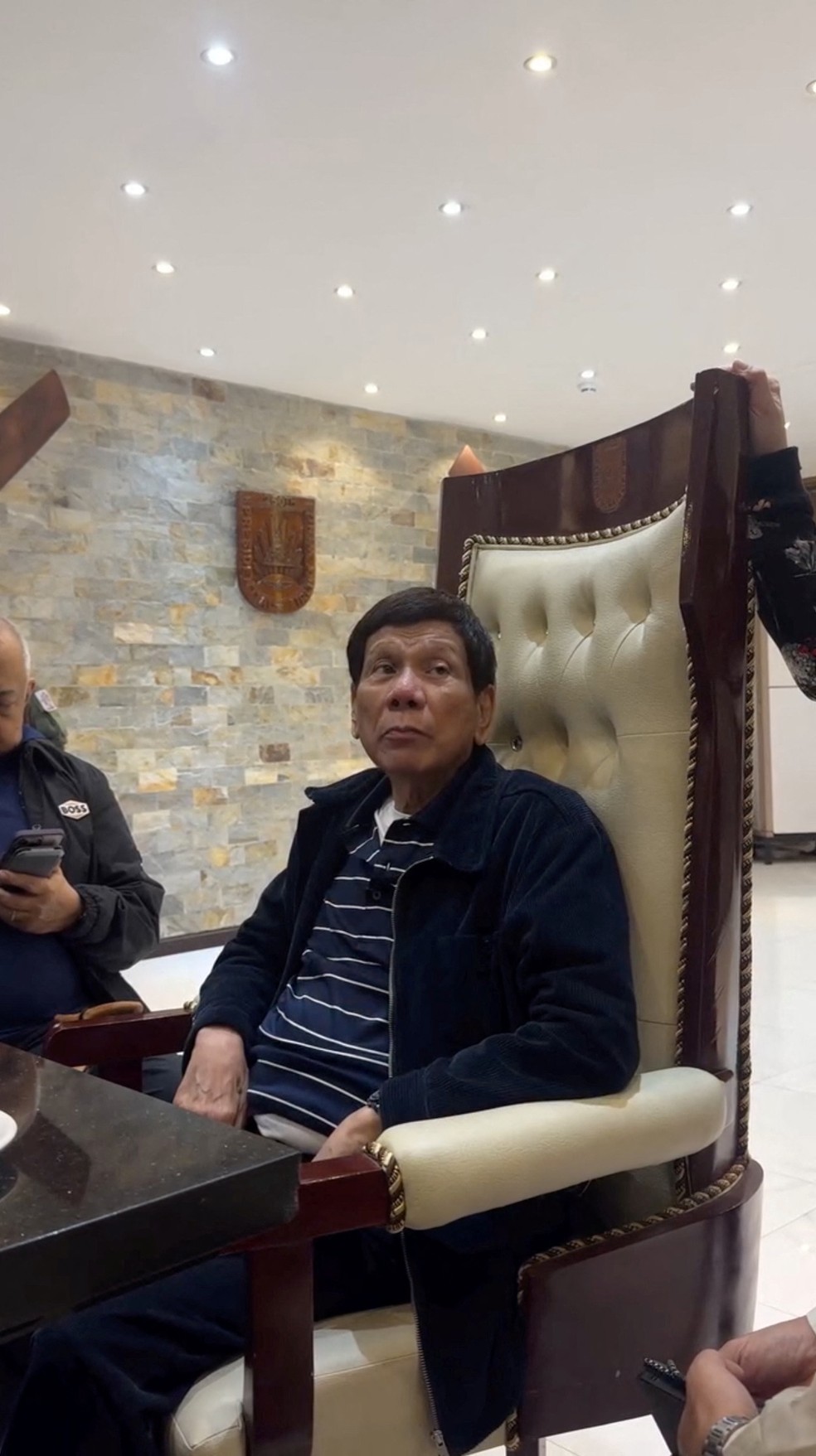 Rodrigo Duterte, ex-presidente das Filipinas, sentado em cadeira após ser preso na Base Aérea Villamor em cumprimento de mandado do Tribunal Penal Internacional em 11 de março de 2025. — Foto: Reprodução/redes sociais via Reuters