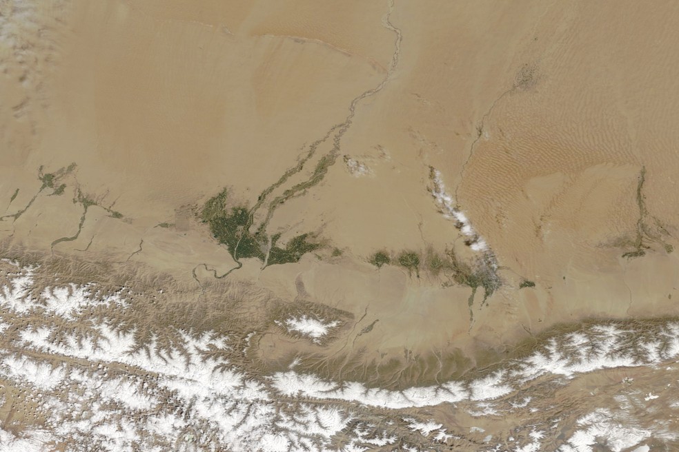 Imagens de satélite mostram o avanço da vegetação na borda do deserto de Taklamacã, no oásis de Hotan. — Foto: NASA Earth Observatory, imagens de Lauren Dauphin, dados MODIS/NASA EOSDIS