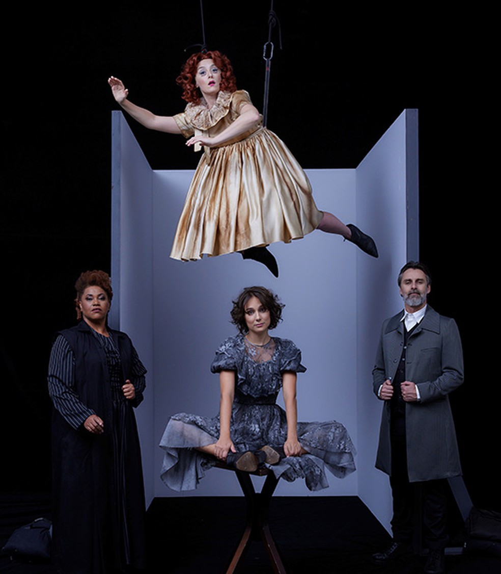 Em apresentação de teatro boneca flutua sobre personagens. — Foto: Divulgação CCBB.