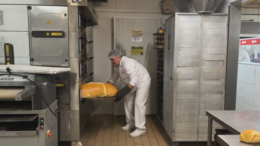 Francisco da Silva retirando pão gigante de 5 quilos do forno em padaria de SP — Foto: Paola Patriarca/g1