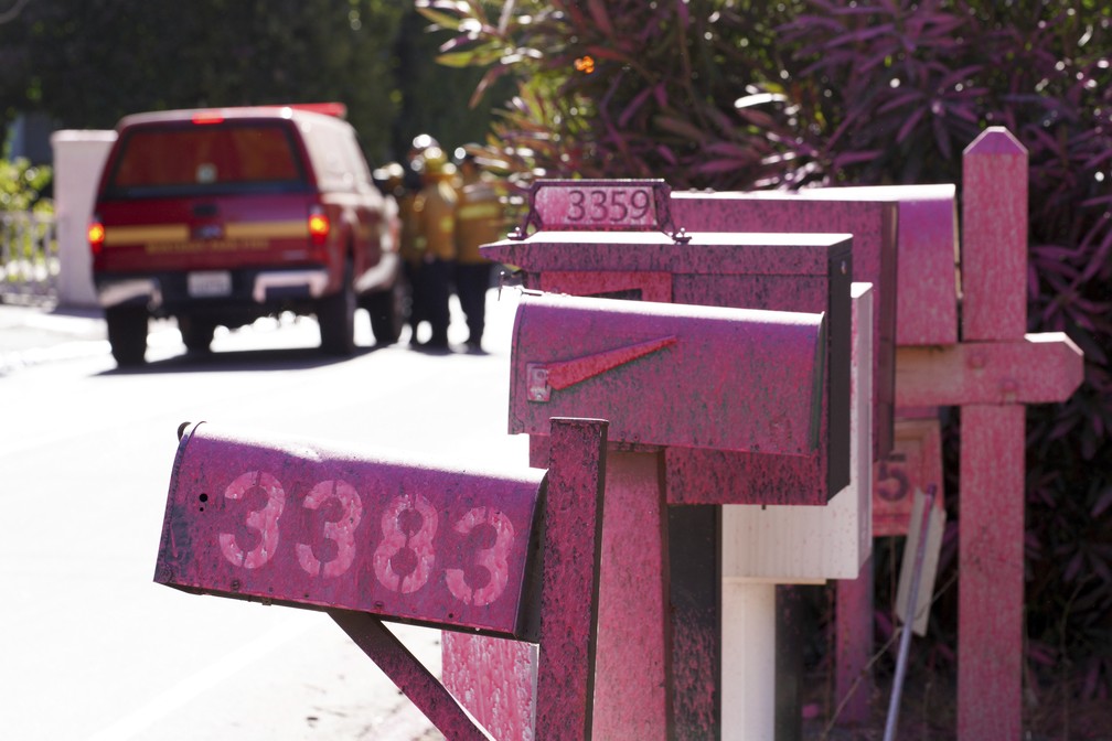 Retardante rosa de fogo cobre caixas de correio em área atingida por incêndio em Mandeville Canyon, Los Angeles — Foto: Richard Vogel/AP