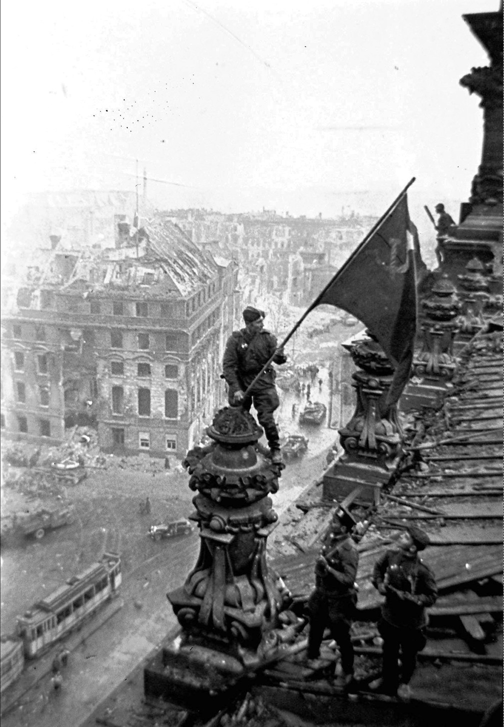Nesta foto de arquivo de 2 de maio de 1945, soldados soviéticos hasteiam a bandeira vermelha sobre o Reichstag após a queda de Berlim, uma das imagens icônicas da Segunda Guerra Mundial tiradas pelo renomado fotógrafo Yevgeny Khaldei — Foto: Yevgeny Khaldei/iTAR-TASS file photo via AP
