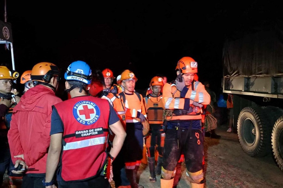 Socorristas buscam por passageiros de ônibus que foram soterrados nas Filipinas — Foto: Philippine Red Cross/AFP